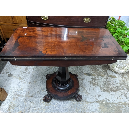 516 - A Regency mahogany folding swivel top card table, the top with circular inset baize, on fluted balus... 