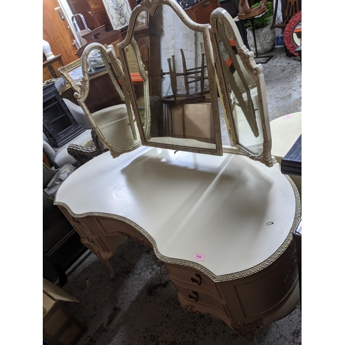 518 - A mid-century cream painted kidney shaped dressing table with triptych swing mirror above a central ... 