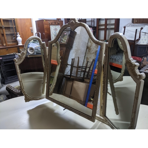 518 - A mid-century cream painted kidney shaped dressing table with triptych swing mirror above a central ... 