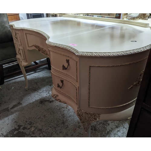 518 - A mid-century cream painted kidney shaped dressing table with triptych swing mirror above a central ... 