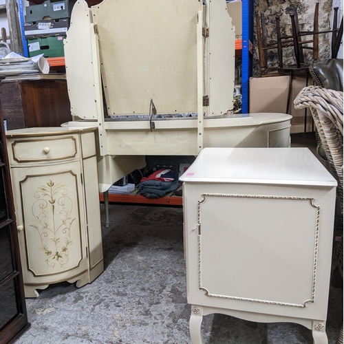 518 - A mid-century cream painted kidney shaped dressing table with triptych swing mirror above a central ... 