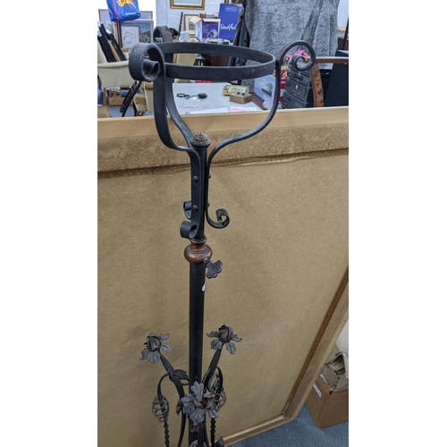 528 - A Victorian wrought iron standard lamp having scroll worked frame and flowers, on splayed legs, 147.... 