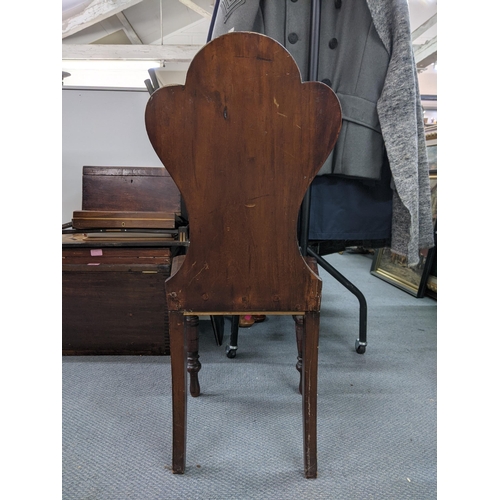 543 - A Victorian mahogany hall chair, the solid carved back with a shield crest motif with a solid seat s... 