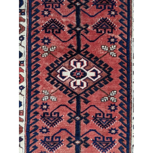 544 - A Turkish rug, the symmetrical blue abstract design on a red background with a central motif having ... 