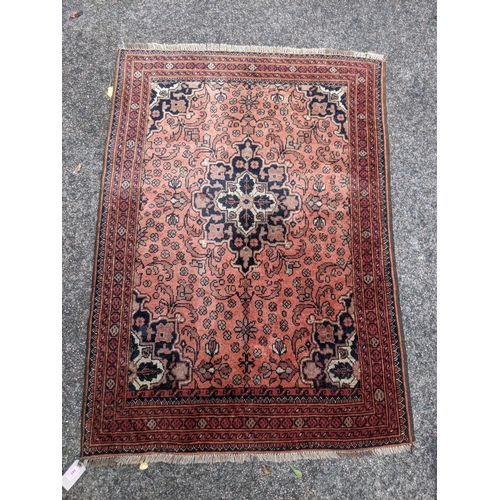 545 - An Iranian Ardakan rug decorated with stylized flowers on a red background with a central medallion ... 