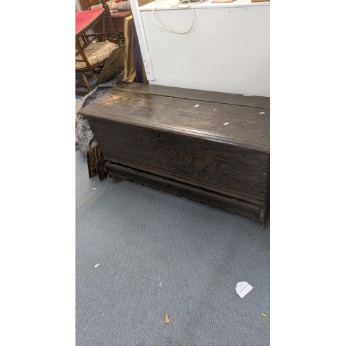 569 - A 17th century oak coffer with a candle tray and lower drawer with an engraved panel 1668 55cm h x 1... 