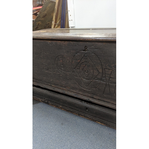 569 - A 17th century oak coffer with a candle tray and lower drawer with an engraved panel 1668 55cm h x 1... 