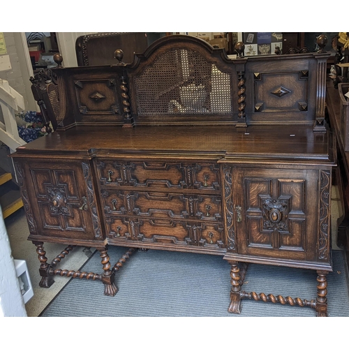 570 - An early 20th century oak sideboard having a raised back, three drawers flanked by cupboard doors an... 