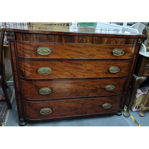 297 - An early 19th century mahogany chest of four drawers, raised on four bun shaped feet and with brass ... 