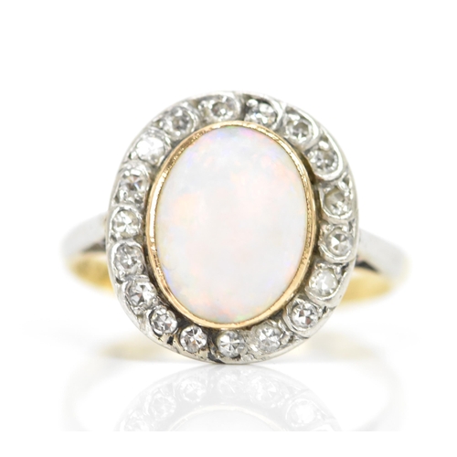 86 - An 18ct yellow gold and platinum opal and diamond cluster ring, the central oval opal surface measur... 