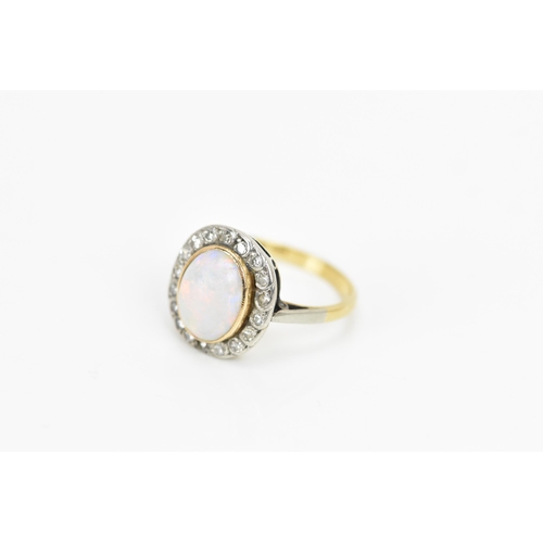 86 - An 18ct yellow gold and platinum opal and diamond cluster ring, the central oval opal surface measur... 