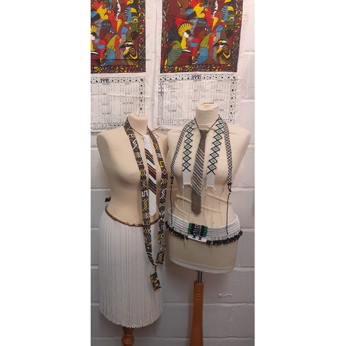 70 - A group of native beaded belts, a skirt and ties to include South African beaded adornments together... 