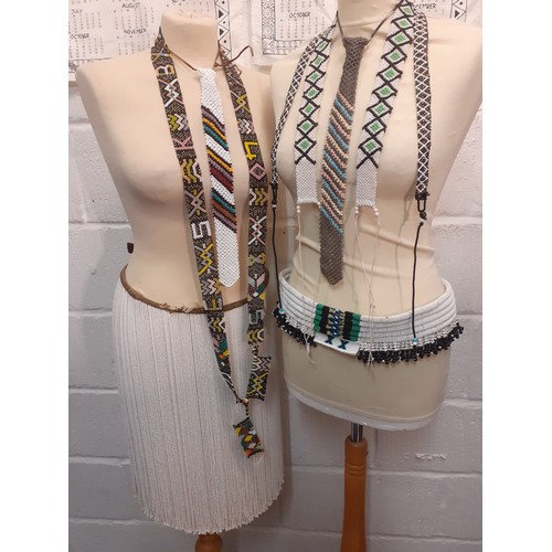 70 - A group of native beaded belts, a skirt and ties to include South African beaded adornments together... 