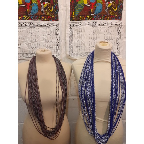 75 - Four native South African multi-string bead necklaces and a quantity of exotic bird printed calendar... 