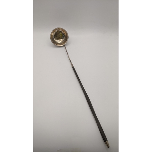 56 - An 18th/19th century silver coloured metal and gilt coin toddy ladle with a whale bowl spoon Locatio... 