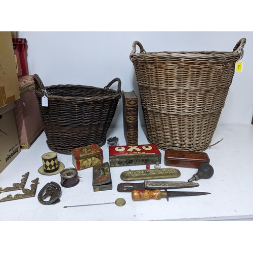 299 - Two wicker baskets containing various vintage tins, one in the form of a top hat, a wooden handled d... 