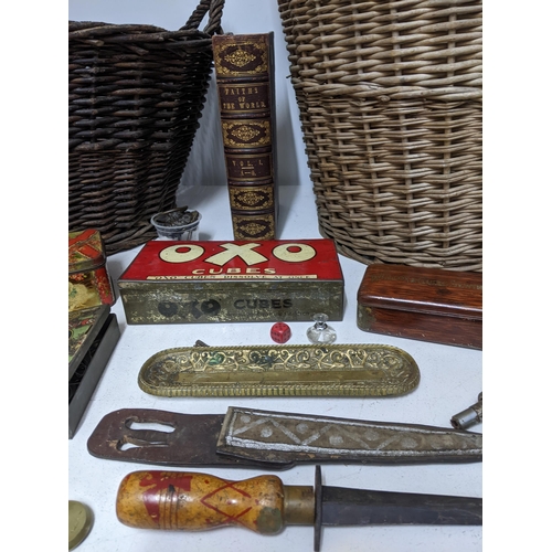 299 - Two wicker baskets containing various vintage tins, one in the form of a top hat, a wooden handled d... 