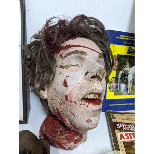 306 - A mixed lot of ephemera, books, TV related and props department items to include a severed head, 33r... 