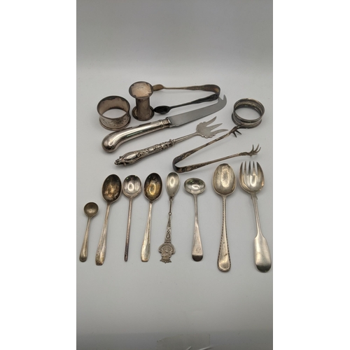 108 - Silver to include three napkin rings, sugar tongs and various spoons, total weight excluding cheese ... 