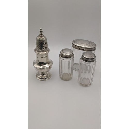 117 - A silver sugar caster hallmarked London 1892, together with three silver lidded dressing table jars,... 