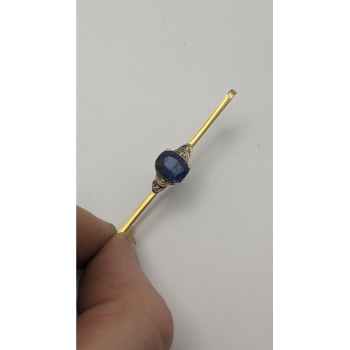129 - A gold and sapphire bar brooch, tested as 15ct gold 2.1g, together with a gold heart shaped locket, ... 