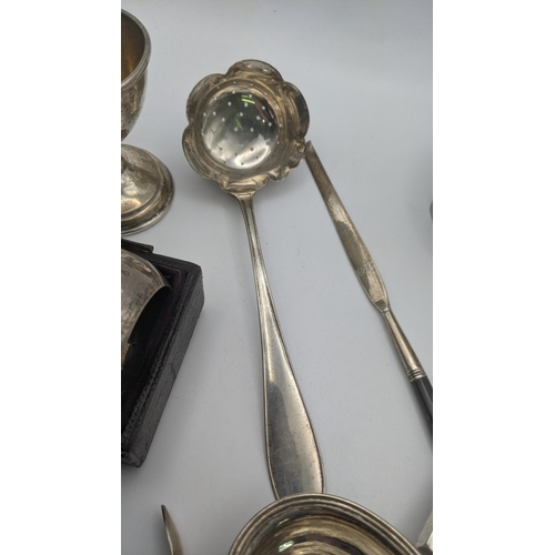 183 - Silver to include a pair of floral engraved napkin rings in a fitted case A/F, a sugar sifter, a tod... 