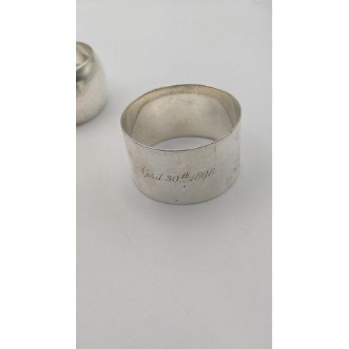 209 - A group of four different napkin rings to include one inscribed April 30th 1898, and others, total w... 