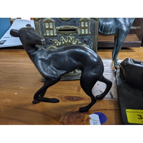 369 - Metalware to include a 19th century money bank, two bronze greyhounds and a composition greyhound Lo... 