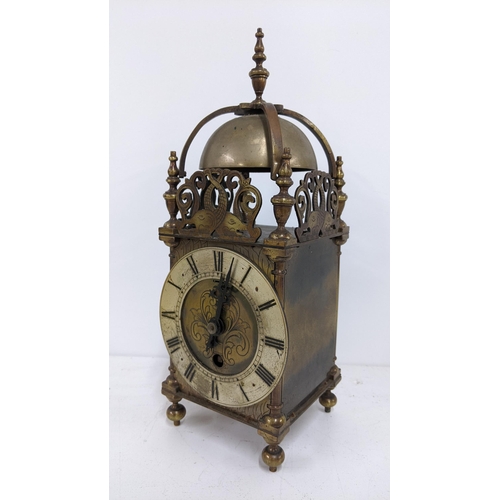 403 - An early 20th century reproduction of a 17th century brass cased lantern clock, having strap work be... 