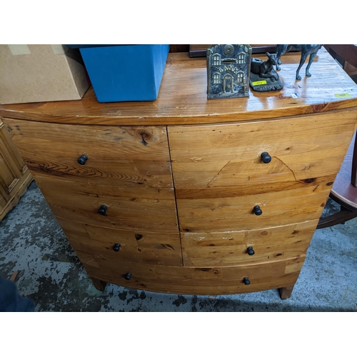 388 - A pitch pine bow fronted chest of six short drawers, over one long drawer, ebonized handles on block... 