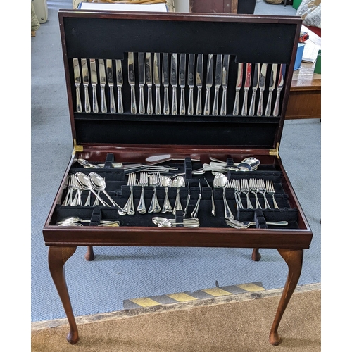 405 - A silver plated canteen of cutlery housed in a  mahogany table with a green leather topped scriber 5... 