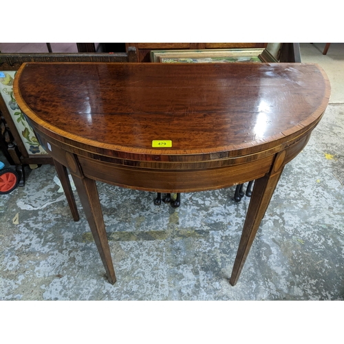 479 - A 19th century inlaid walnut fold over card table, cross banded circular top with inset green baize,... 