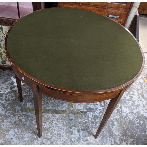 479 - A 19th century inlaid walnut fold over card table, cross banded circular top with inset green baize,... 