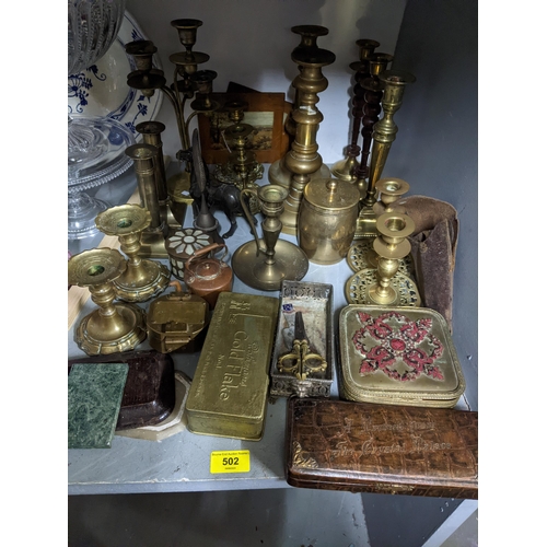 502 - A selection of mixed brassware to include pairs of candlesticks, a leather box with gold coloured co... 