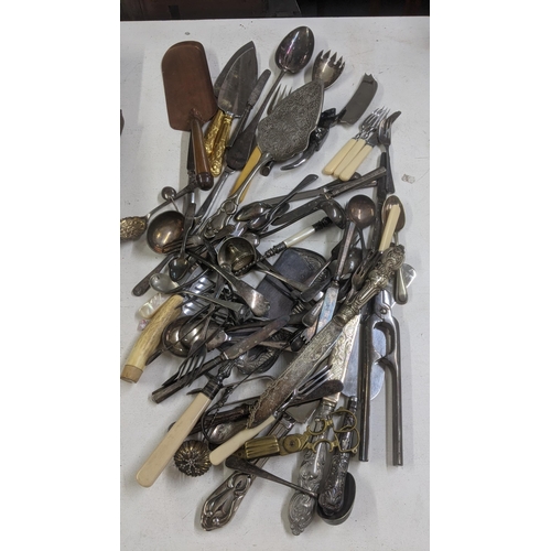 329 - A mixed lot of cutlery and flatware to include a silver plated serving spoon, a cheese knife with ha... 