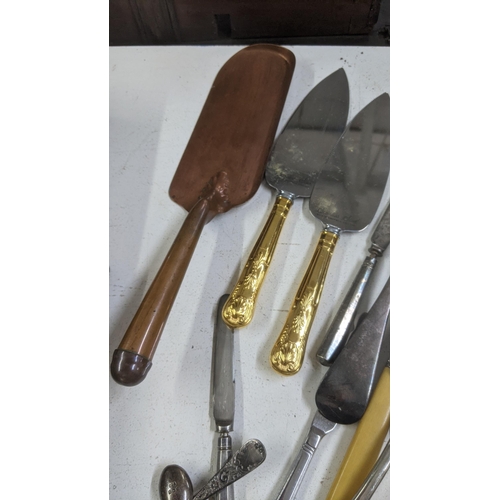 329 - A mixed lot of cutlery and flatware to include a silver plated serving spoon, a cheese knife with ha... 