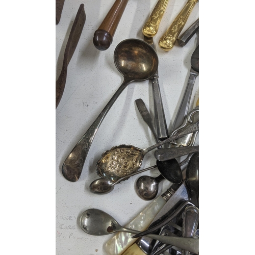 329 - A mixed lot of cutlery and flatware to include a silver plated serving spoon, a cheese knife with ha... 