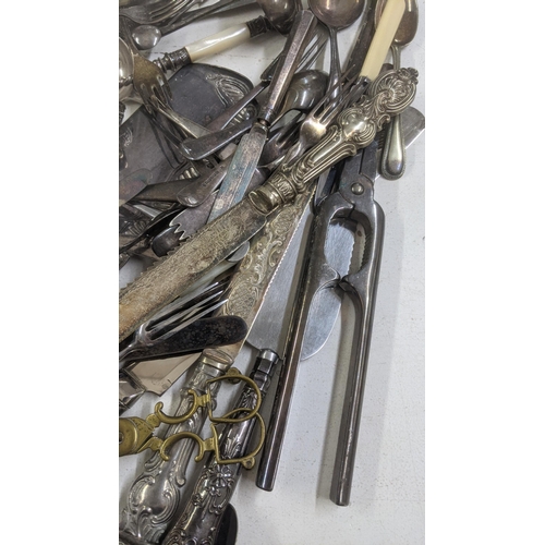 329 - A mixed lot of cutlery and flatware to include a silver plated serving spoon, a cheese knife with ha... 