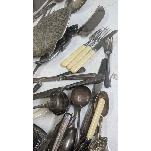 329 - A mixed lot of cutlery and flatware to include a silver plated serving spoon, a cheese knife with ha... 