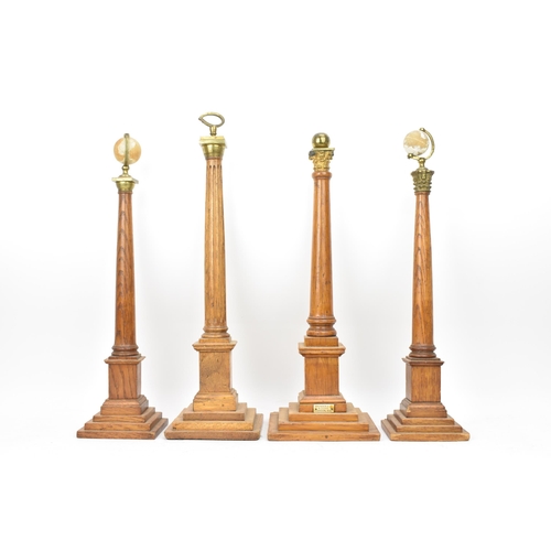 151 - Four early 20th century Masonic oak columns, two mounted with globes, each having a tapered column a... 