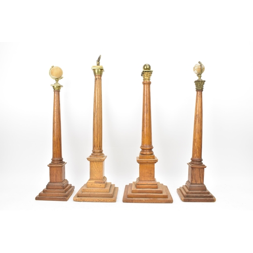 151 - Four early 20th century Masonic oak columns, two mounted with globes, each having a tapered column a... 