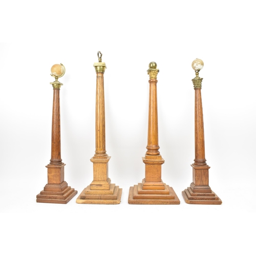 151 - Four early 20th century Masonic oak columns, two mounted with globes, each having a tapered column a... 