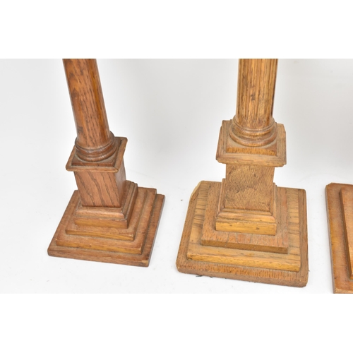 151 - Four early 20th century Masonic oak columns, two mounted with globes, each having a tapered column a... 