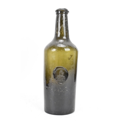 154 - An early 19th century glass seal wine bottle, the tapering neck with sloping rim, the cylindrical bo... 