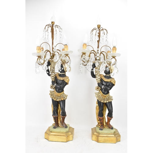 189 - A pair of mid 20th century treen painted blackamoor table lamps, each modelled as a boy holding a co... 