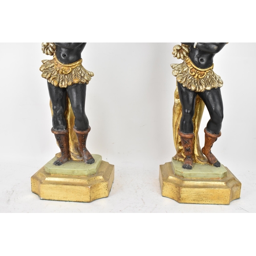 189 - A pair of mid 20th century treen painted blackamoor table lamps, each modelled as a boy holding a co... 