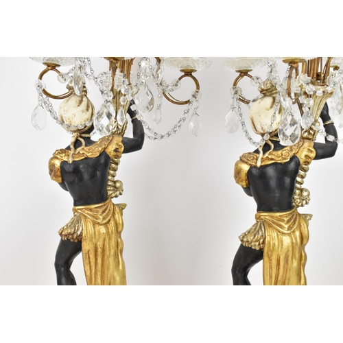 189 - A pair of mid 20th century treen painted blackamoor table lamps, each modelled as a boy holding a co... 