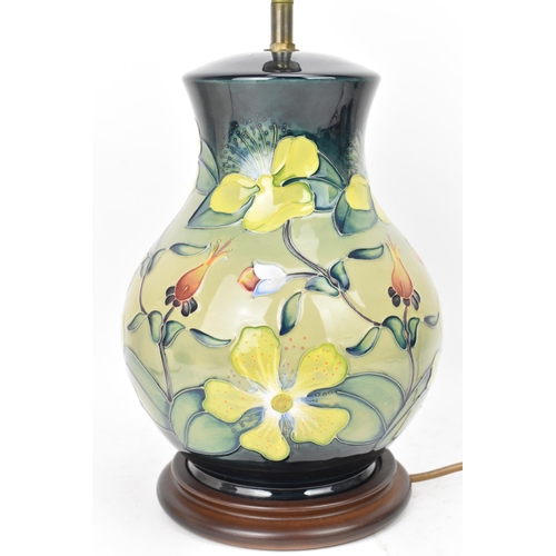 22 - A Moorcroft pottery 'Hypericum' pattern table lamp, designed by Rachel Bishop, of baluster form and ... 