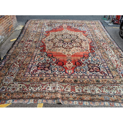 244 - A Persian Heriz hand woven carpet, having a central medallion on a red ground, framed by ivory colou... 