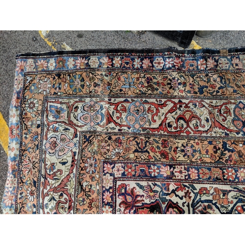 244 - A Persian Heriz hand woven carpet, having a central medallion on a red ground, framed by ivory colou... 